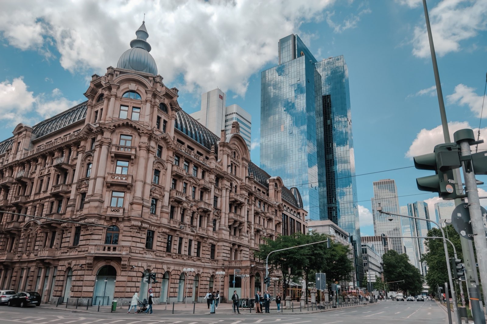 A historic stone building beside glass office towers